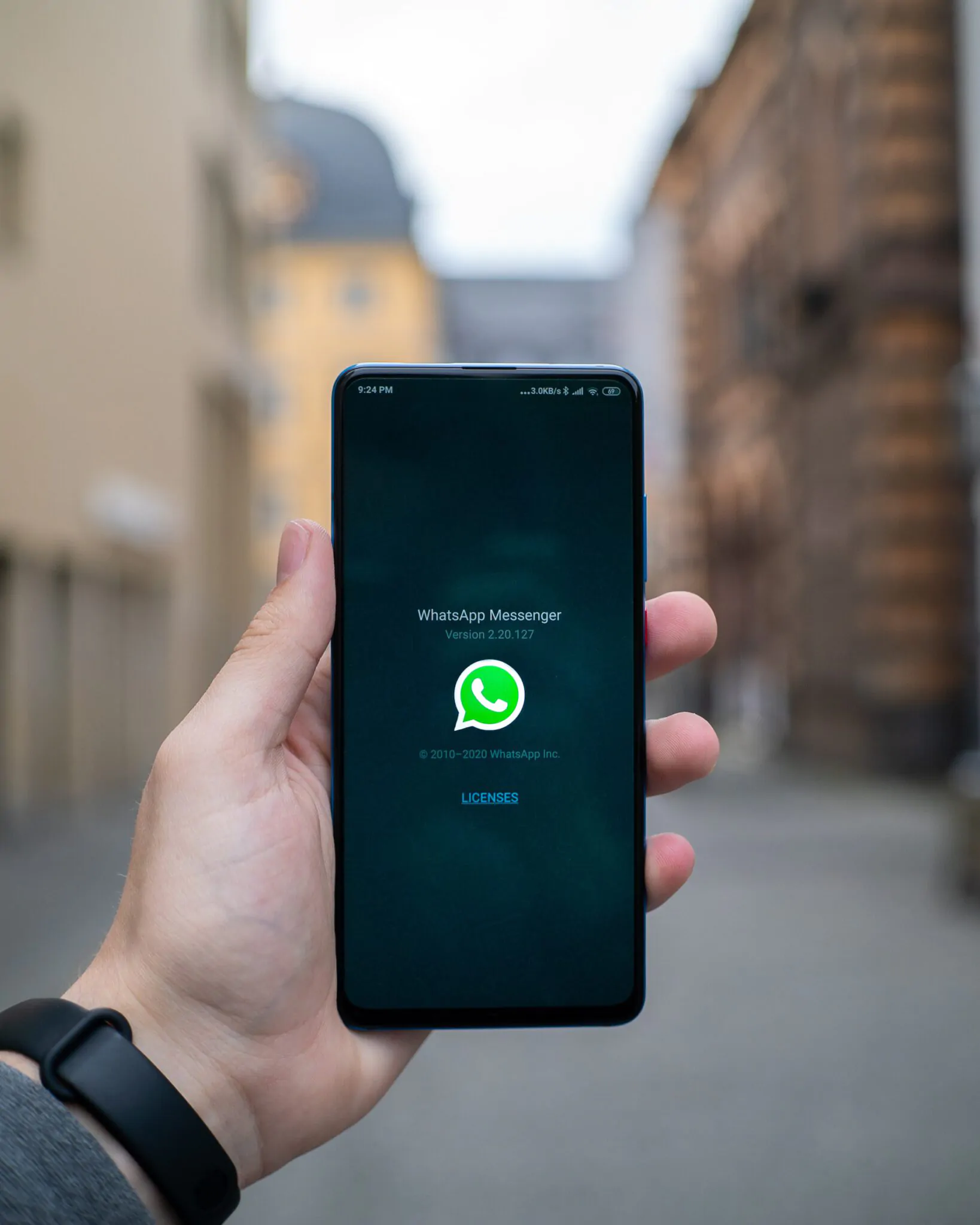 Person hält Handy in der Hand. Man sieht den WhatsApp-Startbildschirm